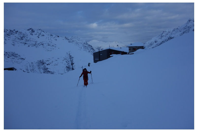 esquiador saliendo del silvrettahutte antes del amanecer